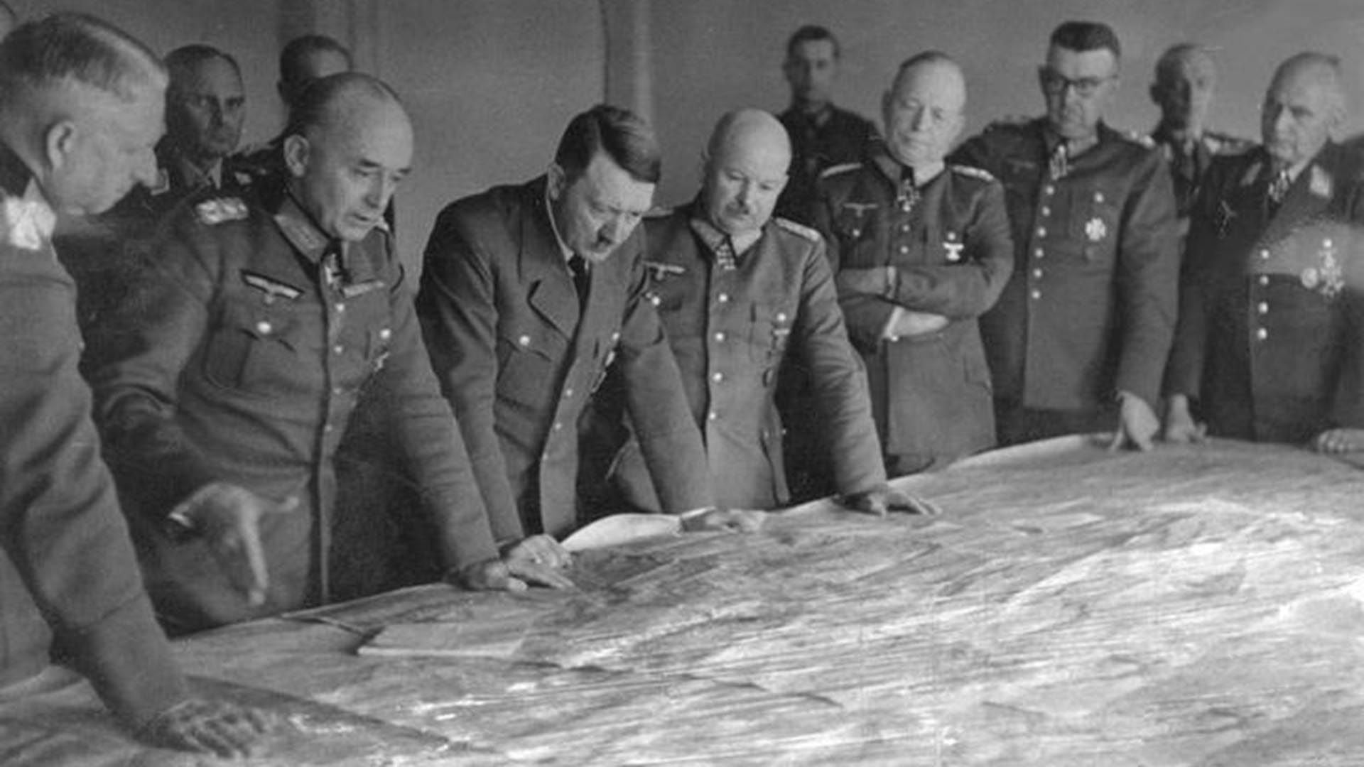 Hitler analiza un enorme mapa de Europa junto a los altos mandos del Grupo de Ejércitos Centro. De allí eran varios de los complotados