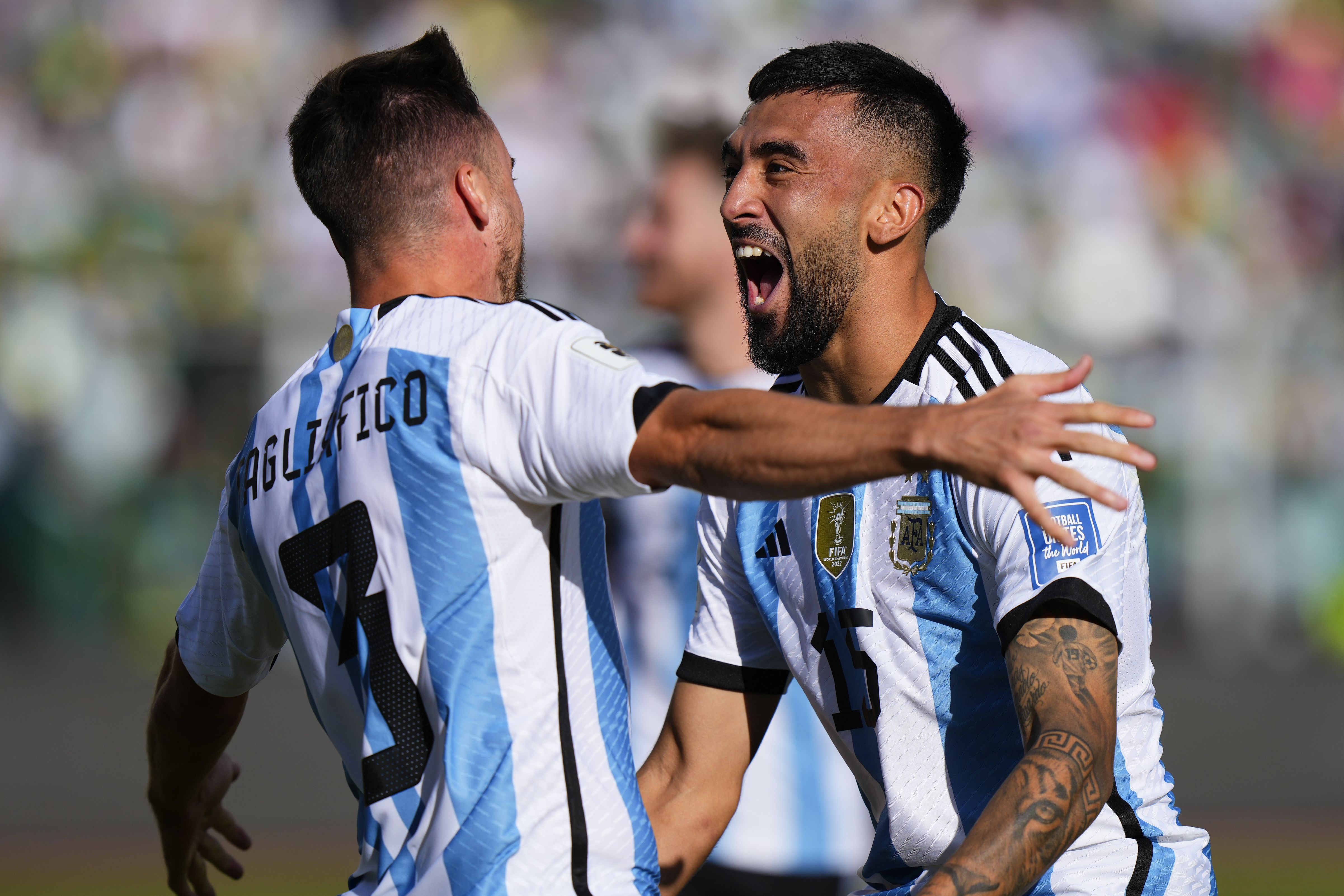 Nicolás Tagliafico (izquierda) celebra con Nicolás González tras anotar el segundo gol de Argentina ante Bolivia por las eliminatorias del Mundial, el martes 12 de septiembre de 2023, en La Paz. (AP Foto/Juan Karita)