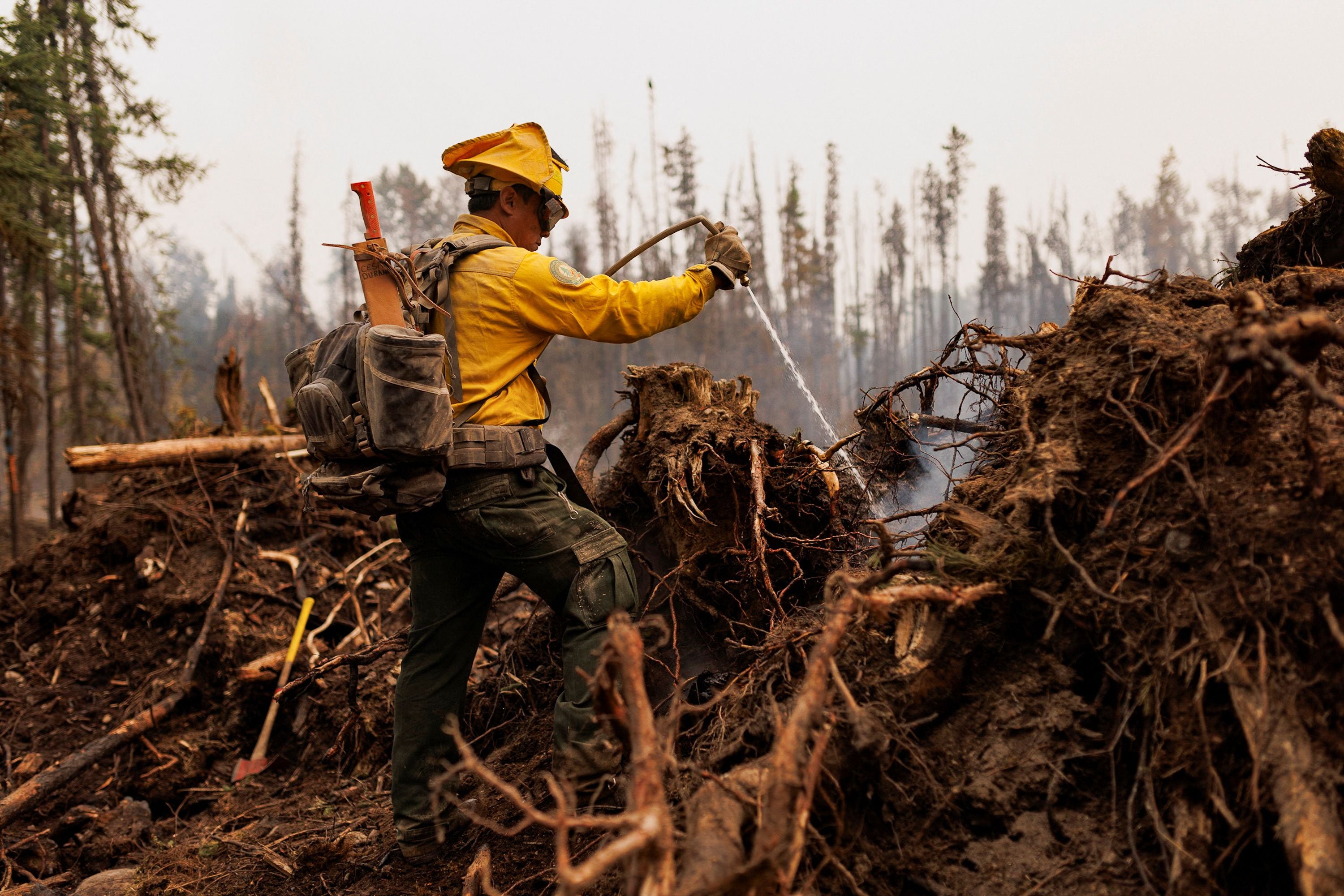 Un bombero de México utiliza una manguera para extinguir puntos calientes en un incendio forestal que arde cerca de Vanderhoof, Columbia Británica, Canadá 13 de julio 2023. REUTERS/Jesse Winter