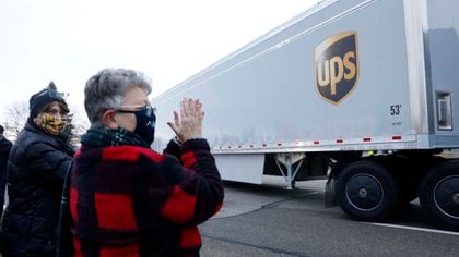 Residentes de Michigan aplauden la salida de camiones de vacunas de la planta de Pfizer (AFP)