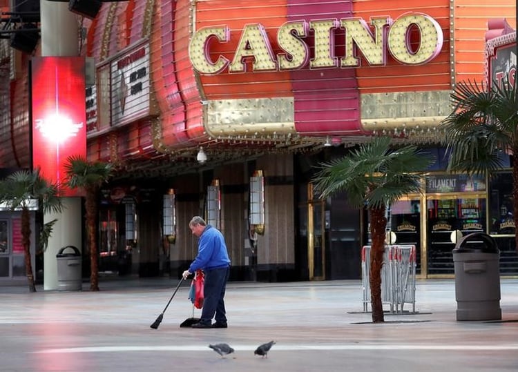 Un trabajador barre la vereda frente a un casino de Las Vegas, EEUU, cuyos negocios han quedado vacíos por las medidas para frenar la pandemia (REUTERS/Steve Marcus)