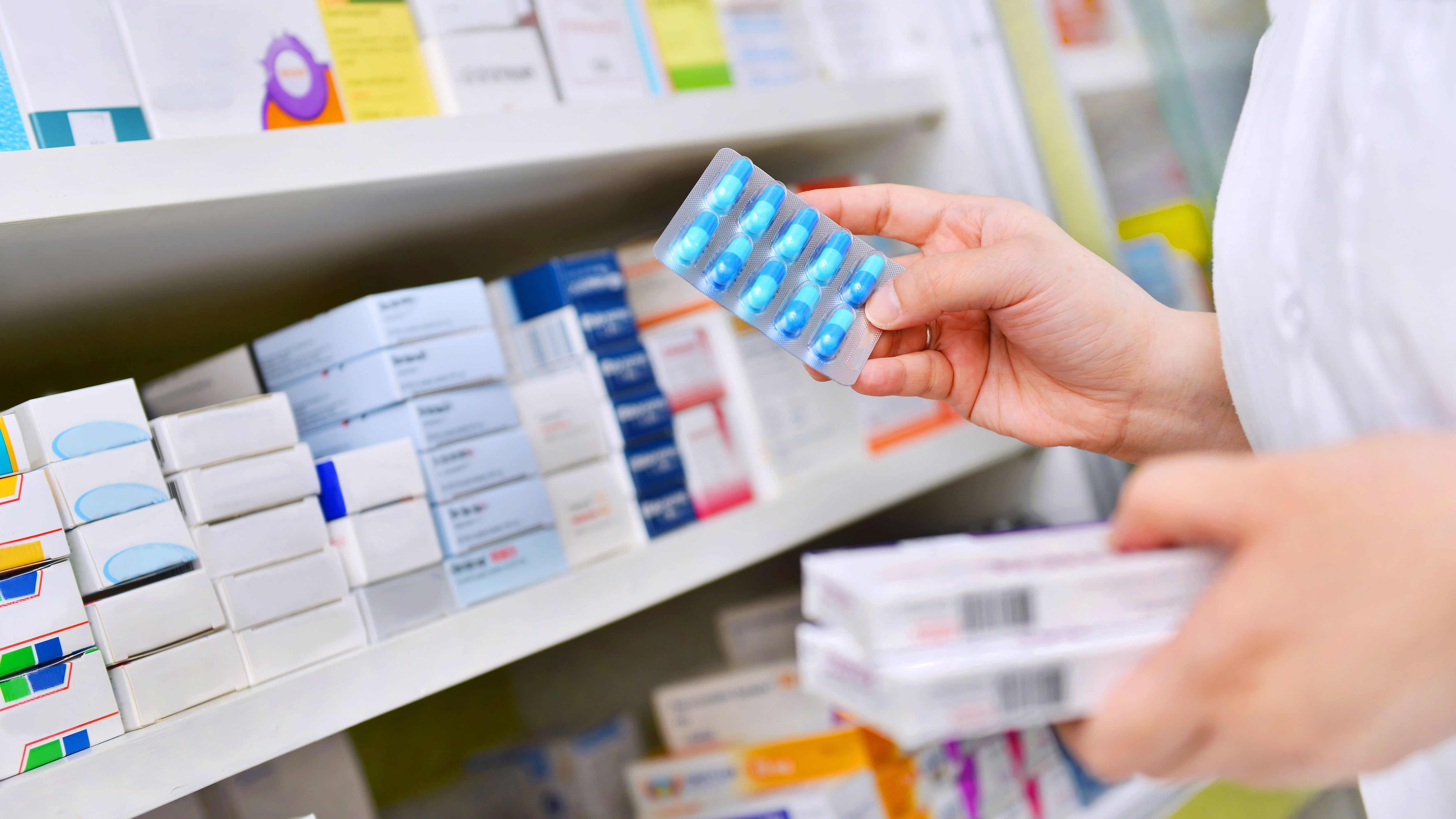 Una farmacéutica sostiene una caja de medicamentos (Shutterstock)