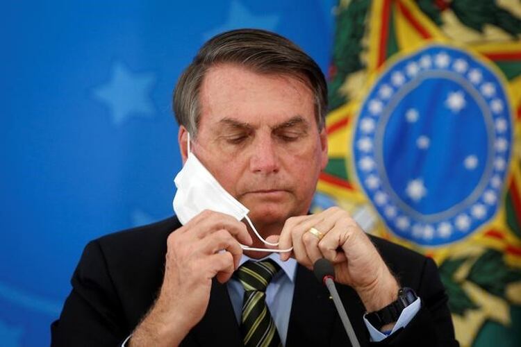 Imagen de archivo del presidente de Brasil, Jair Bolsonaro, ajustando su mascarilla durante una conferencia de prensa para anunciar medidas sobre el coronavirus, en Brasilia, Marzo 18, 2020. REUTERS/Adriano Machado