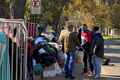 Los migrantes venezolanos varados en las afueras de la embajada venezolana en Santiago de Chile mientras esperan que un vuelo los regrese a su país (REUTERS/Fabian Cambero)
