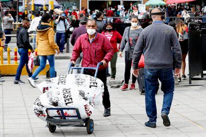 Una calle de Bogotá, concurrida de gente protegida con cubrebocas para evitar los contagios por coronavirus (EFE)