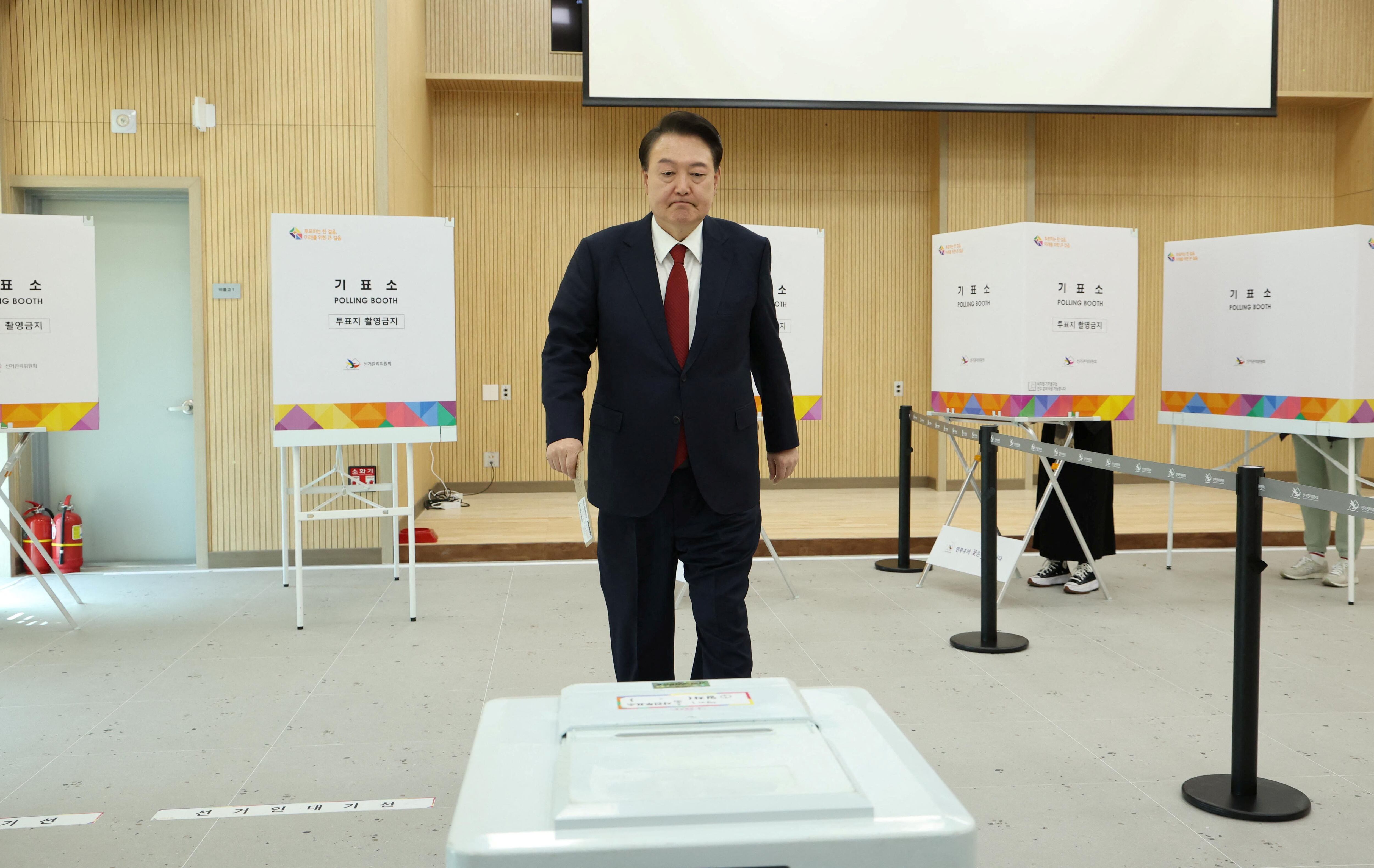 El presidente surcoreano Yoon Suk Yeol depositó su voto anticipado para las 22ª elecciones parlamentarias en Busan, Corea del Sur, el 5 de abril de 2024 (Yonhap vía REUTERS)