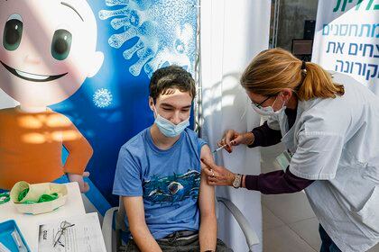 Tomer, an 18-year-old teenager, receives a dose of the Pfizer-BioNtech COVID-19 coronavirus vaccine at Clalit Health Services, in Israel's Mediterranean coastal city of Tel Aviv on January 23, 2021. - Israel began administering novel coronavirus vaccines to teenagers as it pushed ahead with its inoculation drive, with a quarter of the population now vaccinated, health officials said. (Photo by JACK GUEZ / AFP)