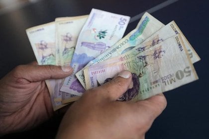 Foto de archivo ilustrativa de un empleado con varios billetes de pesos colombianos en una tienda en Bogotá. 
Dic 28, 2018. REUTERS/Luisa Gonzalez