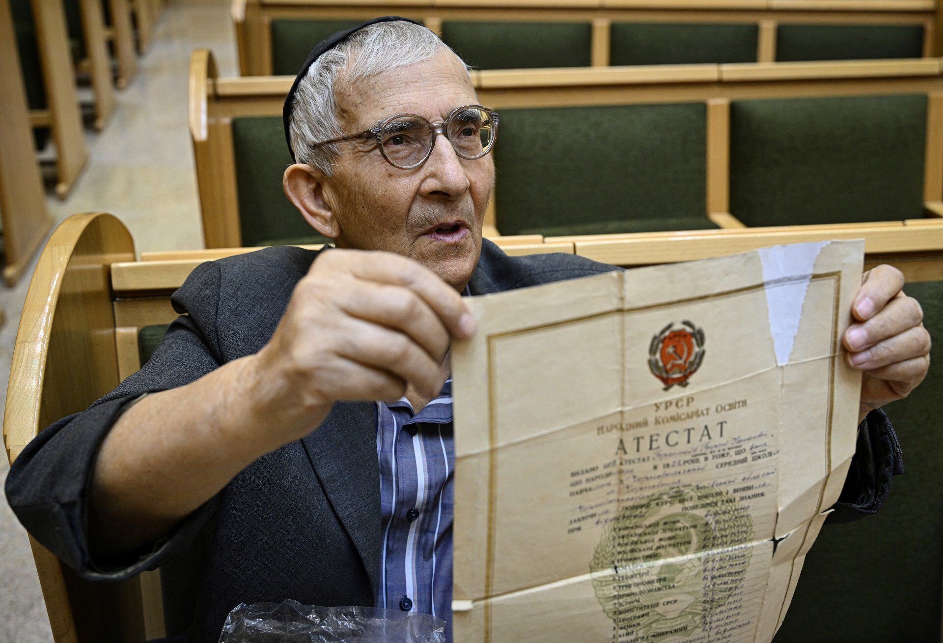 Roman Gerstein, 83-years-old, shows a document from his family archives during an interview with AFP at the Synagogue of Kryvyj Rig, central Ukraine, on September 22, 2022, as the Russia-Ukraine war enters its 211th day. - For some of the Ukranian survivors of the Shoah or Holocaus that caused some 1.5 million deaths in Ukraine, today "there are no nazis" in their country, as opposed to what Moscow's Kremlin says as one of its justifications for the Russian invasion of Ukraine on February 24, 2022. (Photo by Genya SAVILOV / AFP)