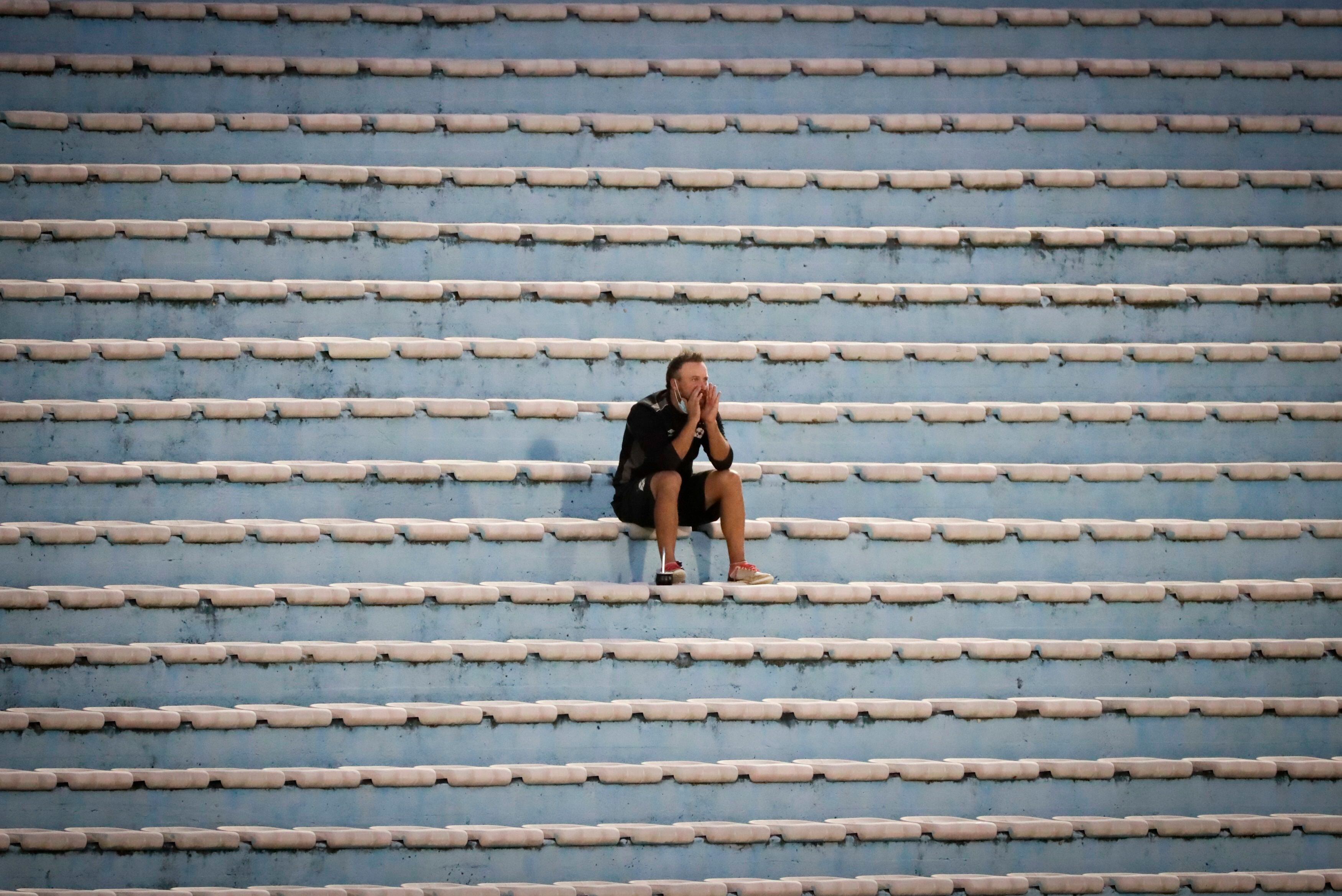 Fotografía de archivo tomada el pasado 2 de mayo en la que se registró a un hombre al observar la final de la Supercopa Uruguaya de Fútbol 2021, entre Wanderers y Nacional, en el Estadio Centenario, en Montevideo (EFE/Raúl Martínez)