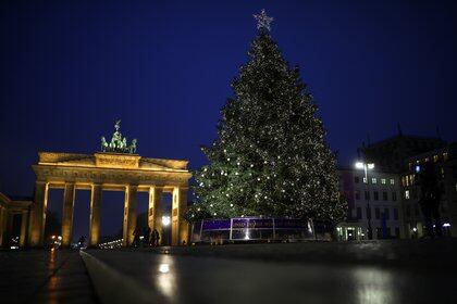 Un árbol de Navidad se ilumina frente a la Puerta de Brandenburgo en Berlín, Alemania, el 26 de noviembre de 2020. REUTERS/Hannibal Hanschke