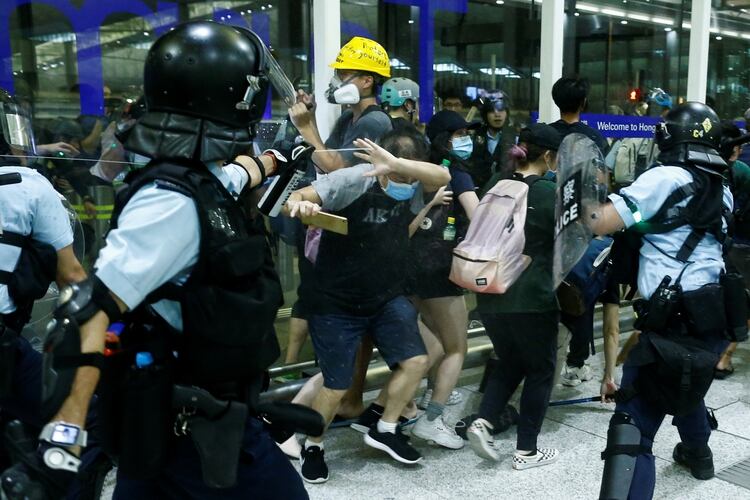 Un policÃ­a dispara gas pimienta contra un grupo de manifestantes (REUTERS/Thomas Peter)