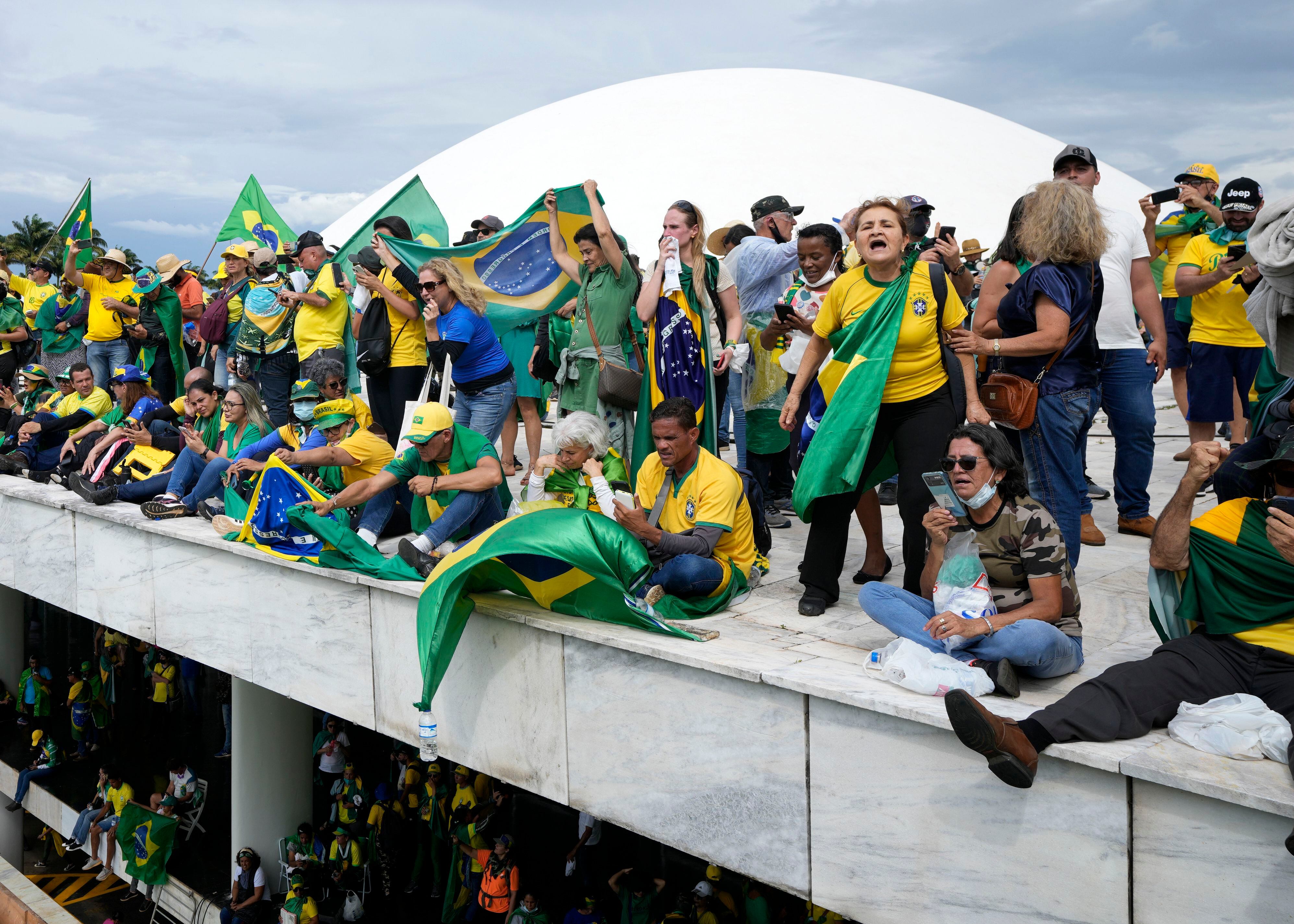 Manifestantes, simpatizantes del ex presidente brasileño Jair Bolsonaro, en el techo del edificio del Congreso Nacional después de irrumpir en el recinto, el 8 de enero de 2023. (AP Foto/Eraldo Peres, Archivo)