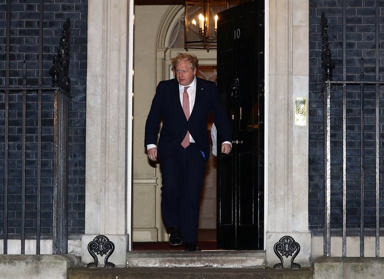 El primer ministro británico Boris Johnson saliendo de la puerta del 10 de Downing Street antes de aplaudir durante la campaña en apoyo del Servicio Nacional de Salud, el 26 de marzo de 2020 (REUTERS/Hannah McKay)