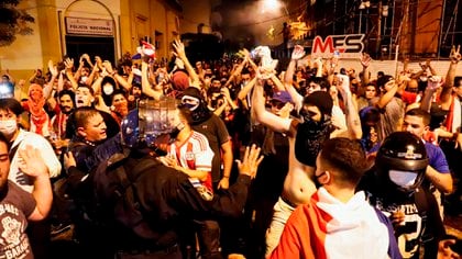 Efectivos de la policía nacional retroceden este viernes, durante una manifestación en Asunción (EFE/Nathalia Aguilar)