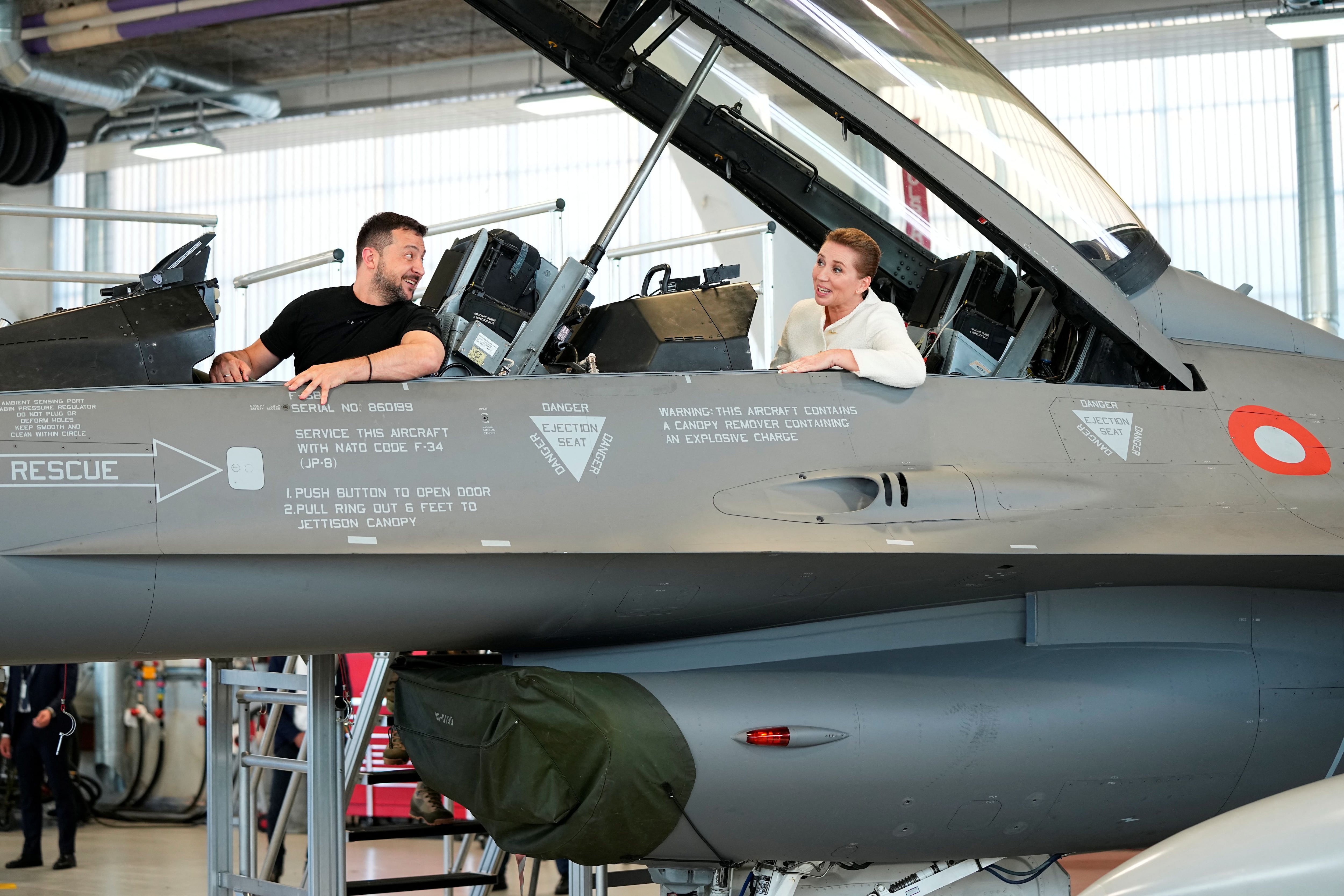 El presidente ucraniano Volodymyr Zelenskiy y la primera ministra de Dinamarca, Mette Frederiksen, se sientan en un avión de combate F-16 en la base aérea de Skrydstrup en Vojens, Dinamarca, el 20 de agosto de 2023. Ritzau Scanpix/Mads Claus Rasmussen vía REUTERS