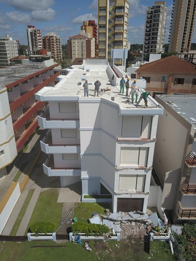 Personal de bomberos y de la municipalidad trabajando en la terraza del complejo 