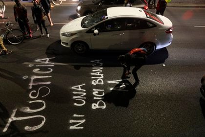 MEX4961. CIUDAD DE MÉXICO (MÉXICO), 12/02/2021.- Un ciclista escribe en pintura un mensaje en la calle durante un bloqueo como protesta hoy, en Ciudad de México (México). Un centenar de ciclistas bloquearon este viernes una céntrica avenida de Ciudad de México bajo el lema "Viernes de Revancha", en respuesta a la agresión policial que sufrieron la semana pasada cuando exigían mayor seguridad para los usuarios de bicicletas. EFE/ Sáshenka Gutiérrez 
