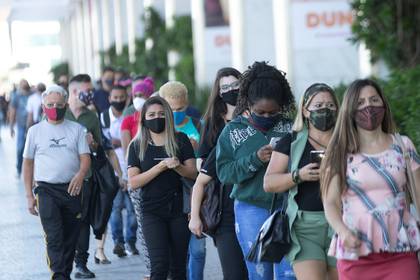 Cientos de personas con tapabocas hacen fila en un centro comercial de Brasilia (EFE/ Joédson Alves)