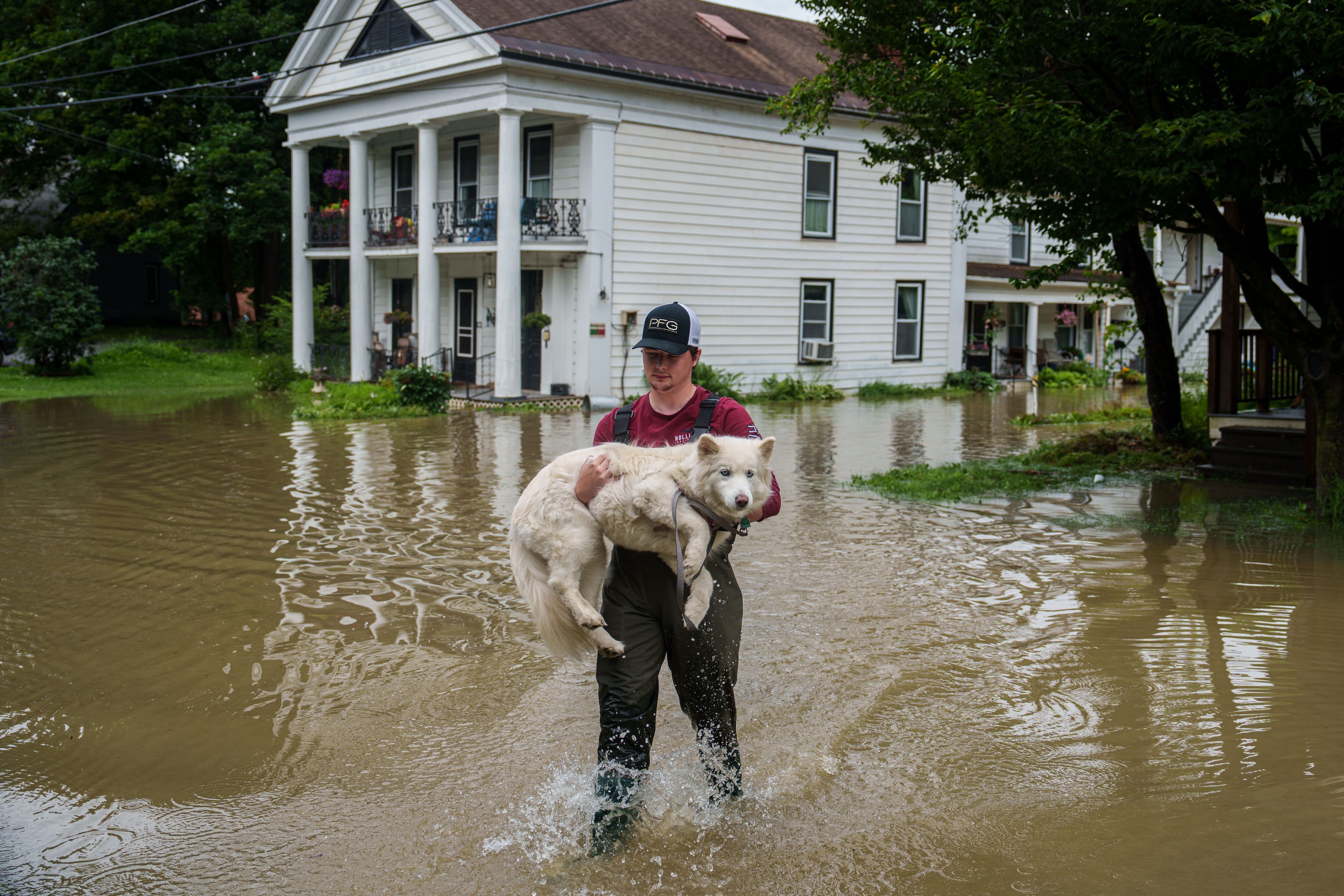 There was massive flooding in the Northeast this week, in particular Vermont, where Tyler Jovic carried his neighbor's dog to dry ground. MUST CREDIT: Photo for The Washington Post by John Tully