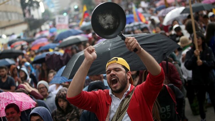 Un hombre golpea una olla en las calles de Bogotá (Reuters)