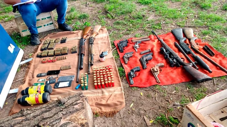 Bandera del MP 22 de Agosto y las armas encontradas en el operativo.