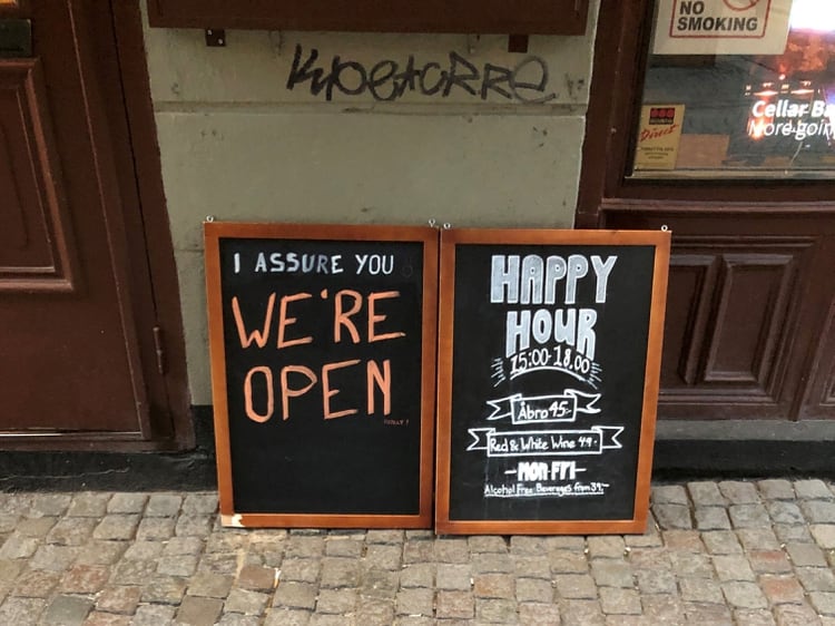 Un letrero asegura a las personas que el bar está abierto durante el brote de coronavirus, afuera de un pub en Estocolmo (Reuters)