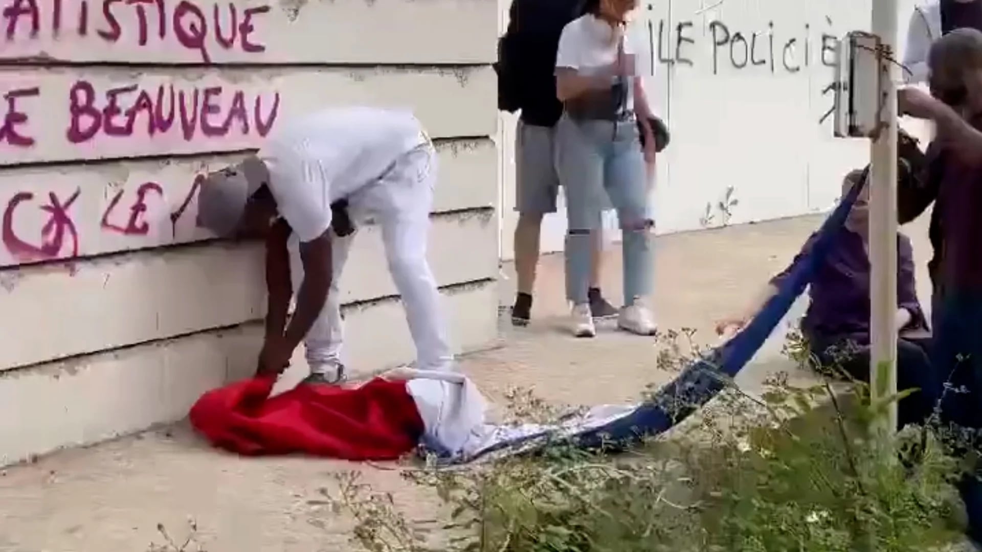Un manifestante intenta quemar la bandera de Francia