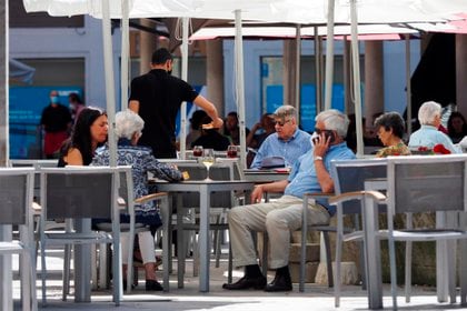 Personas disfrutan de un soleado día en la terraza de un restaurante en la plaza de la Rinconada, este domingo 21 de junio de 2020, en Valladolid. Después de 98 días de estado de alarma, Castilla y León entraron en una "nueva normalidad" regida por medidas que, aunque más relajadas que las anteriores, tratarán de preservar la prevención y el control de la COVID-19 (EFE/ R. García)
