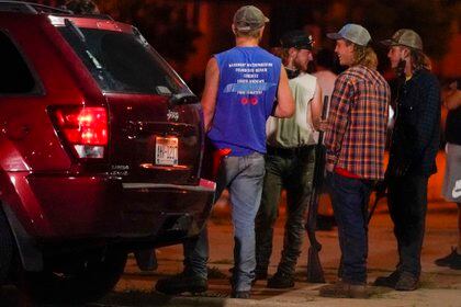 Un grupo sostiene rifles mientras observan a los manifestantes en la calle el martes 25 de agosto de 2020 en Kenosha, Wisconsin. Las protestas continuaron luego del tiroteo de la policía contra Jacob Blake dos días antes. (Foto AP / Morry Gash)