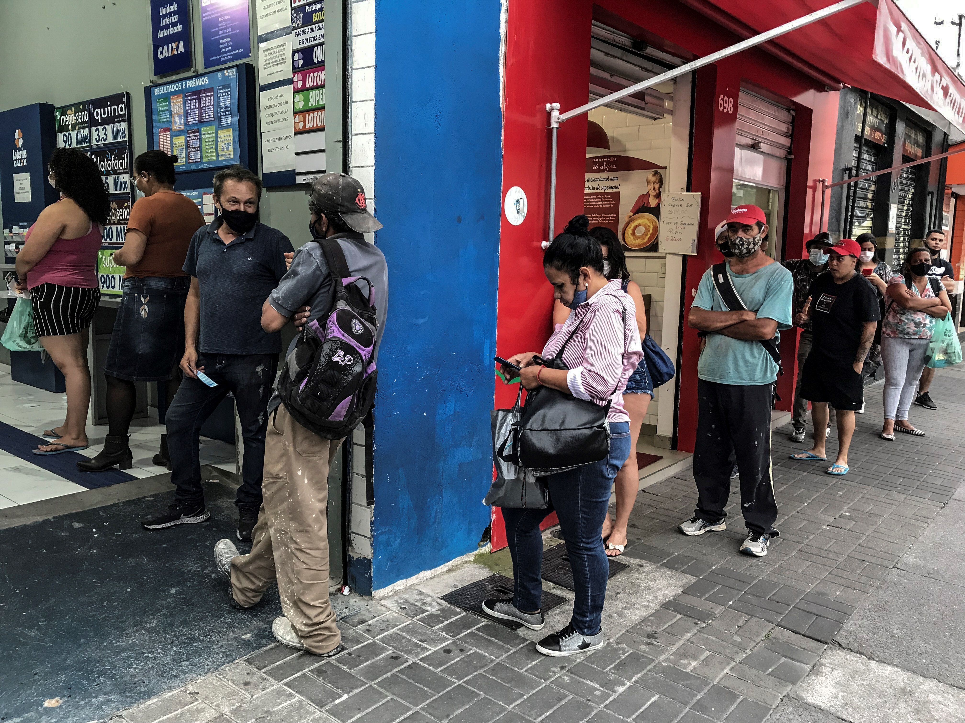 Varias personas esperan para ingresar a un establecimiento, en una ciudad en Brasil, en una fotografía de archivo.EFE/ Sebastiao Moreira