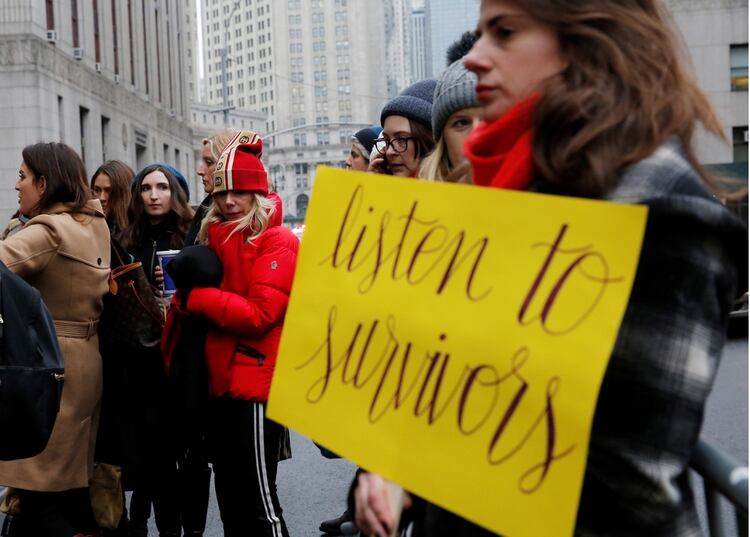 La actriz Rosanna Arquette observa uno de los carteles de los manifestantes frente a la Corte en Manhattan que dice 