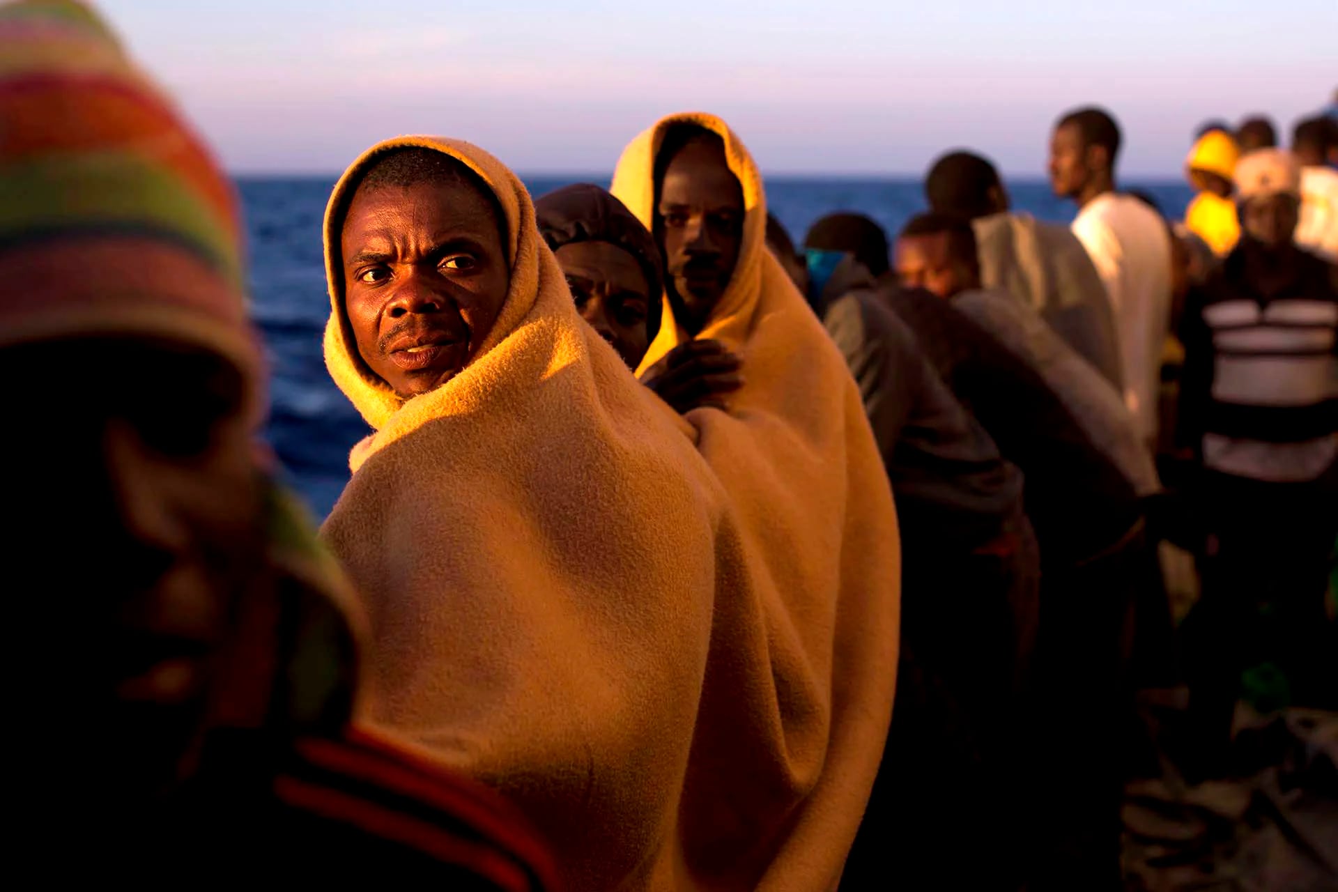 Migrantes en la cubierta del buque de rescate Golfo Azzurro en el mar Mediterráneo