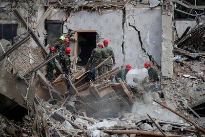 Equipos de búsqueda y rescate trabajan en el lugar de la explosión del cohete durante los combates en la región separatista de Nagorno-Karabaj en la ciudad de Ganja, Azerbaiyán.  REUTERS / Umit Bektas