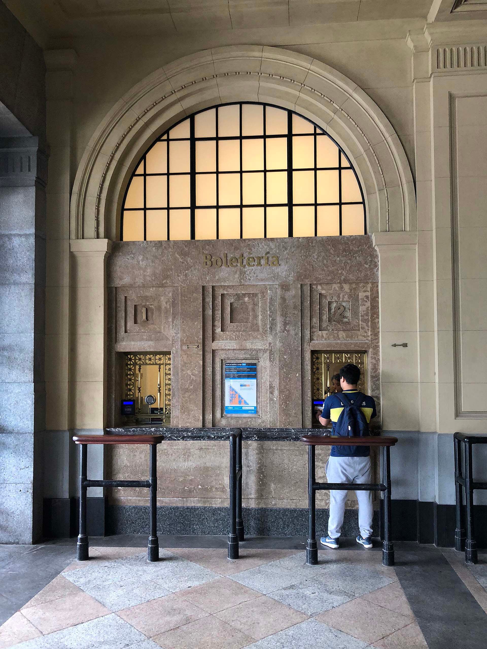 Estación Constitución, un domingo por la tarde, un hincha de Boca carga su SUBE para ir a la Bombonera. Una imagen clásica que descubre además la identidad futbolera del artista