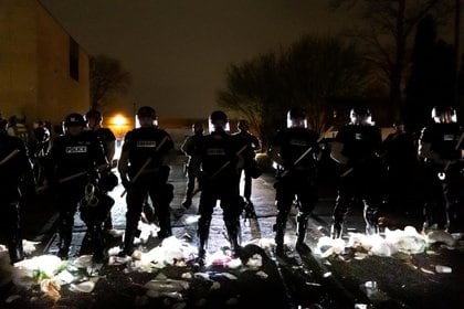 Los oficiales de policía hacen fila frente a la estación de policía del Brooklyn Center mientras la gente protesta después de que un oficial disparó y mató a un hombre negro en el Brooklyn Center, Minneapolis, Minnesota el 11 de abril de 2021.  (Photo by Kerem Yucel / AFP)