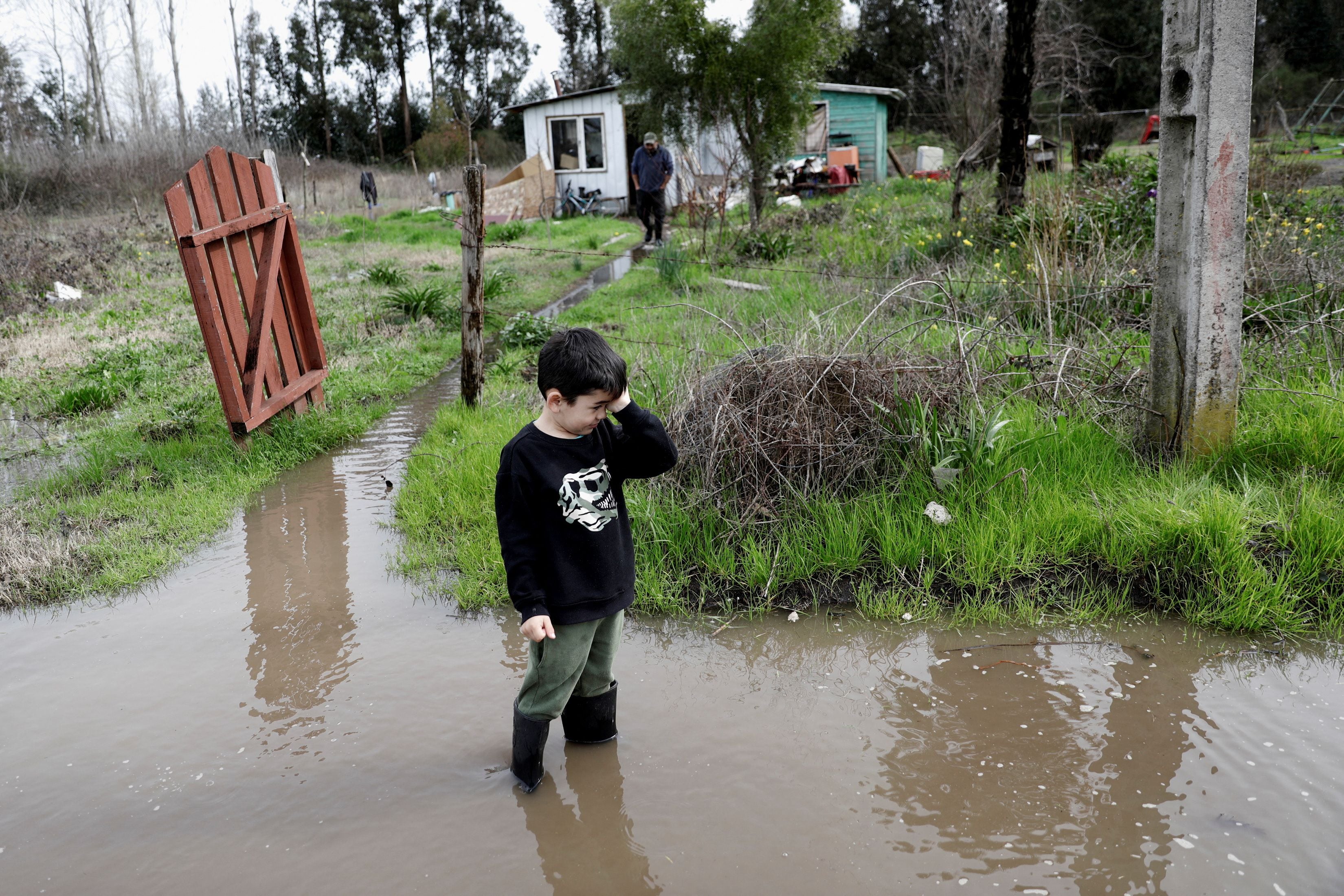 Un niño llora frente a su casa inundada en la zona centro-sur de Chile, en Cabrero (REUTERS/Juan Gonzalez)