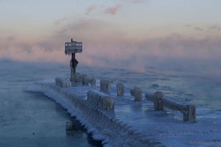 El faro de un puerto está cubierto por hielo y nieve sobre el lago Michigan en Chicago, 30 de enero de 2019. (AP Foto/Nam Y. Huh)