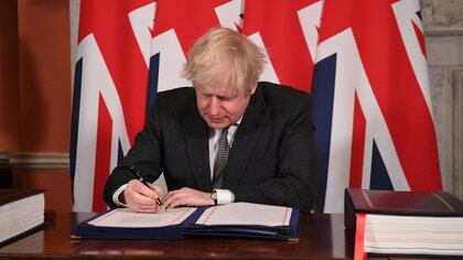 Britain's Prime Minister Boris Johnson signs the Brexit trade deal with the EU at number 10 Downing Street in London, Britain December 30, 2020. Leon Neal/Pool via REUTERS