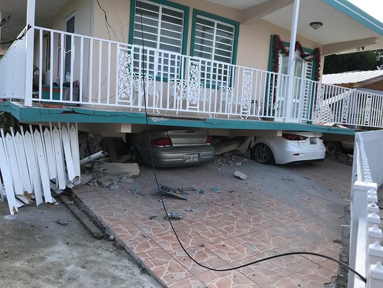 Autos destruidos bajo una casa que colapsó en Guanica (Reuters)