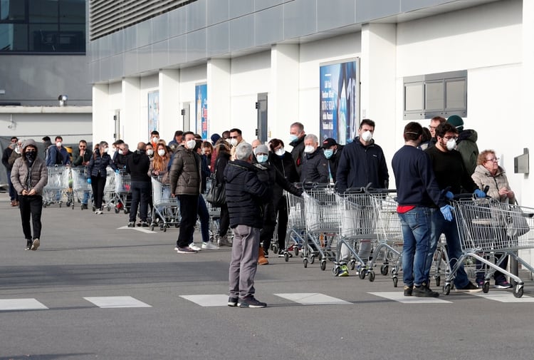 Larguísimas filas de clientes afuera de un supermercado en Casalpusterlengo (REUTERS/Guglielmo Mangiapane)