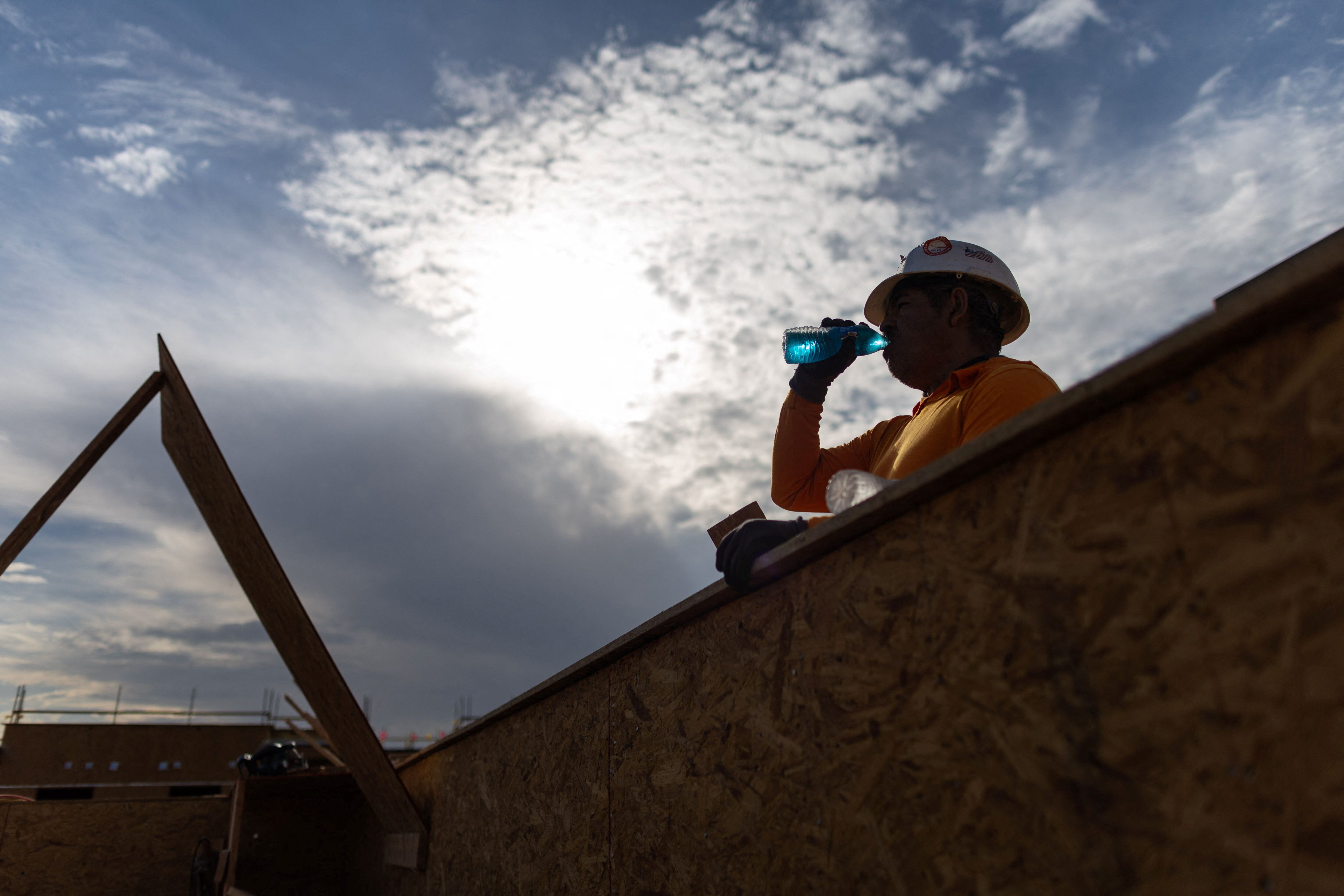 Un trabajador de la construcción bebe una bebida fría durante una ola de calor donde las temperaturas superan los 110 grados Fahrenheit durante 27 días consecutivos, en Scottsdale, en el área metropolitana de Phoenix, Arizona, EE.UU., 28 de julio de 2023.   REUTERS/Carlos Barria