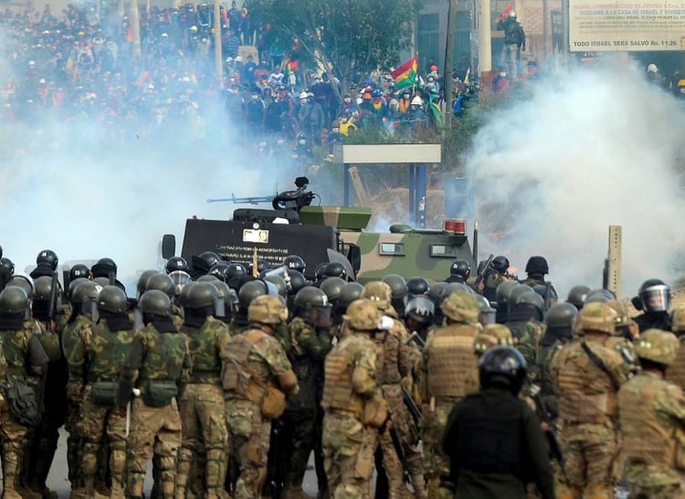 Bolivian riot police and soldiers clash with supporters of Bolivia's ex-President Evo Morales during a protest against the interim government in Sacaba, Chapare province, Cochabamba department on November 15, 2019. - Bolivia's interim president Jeanine Anez said Friday that exiled ex-president Evo Morales would have to 