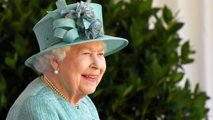 La reina llevó un abrigo verde pálido, pamela a tono, su collar de perlas de varias vueltas y un bolso negro (TOBY MELVILLE / POOL / AFP)
