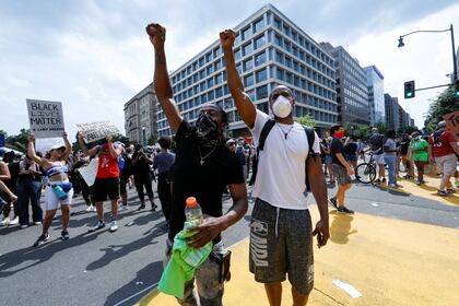 Manifestantes levantan los puños en una manifestación por los derechos civiles y la cultura negra mientras se reúnen en la Black Lives Matter Plaza, cerca de la Casa Blanca, el 6 de junio de 2020. (REUTERS/Jim Bourg)