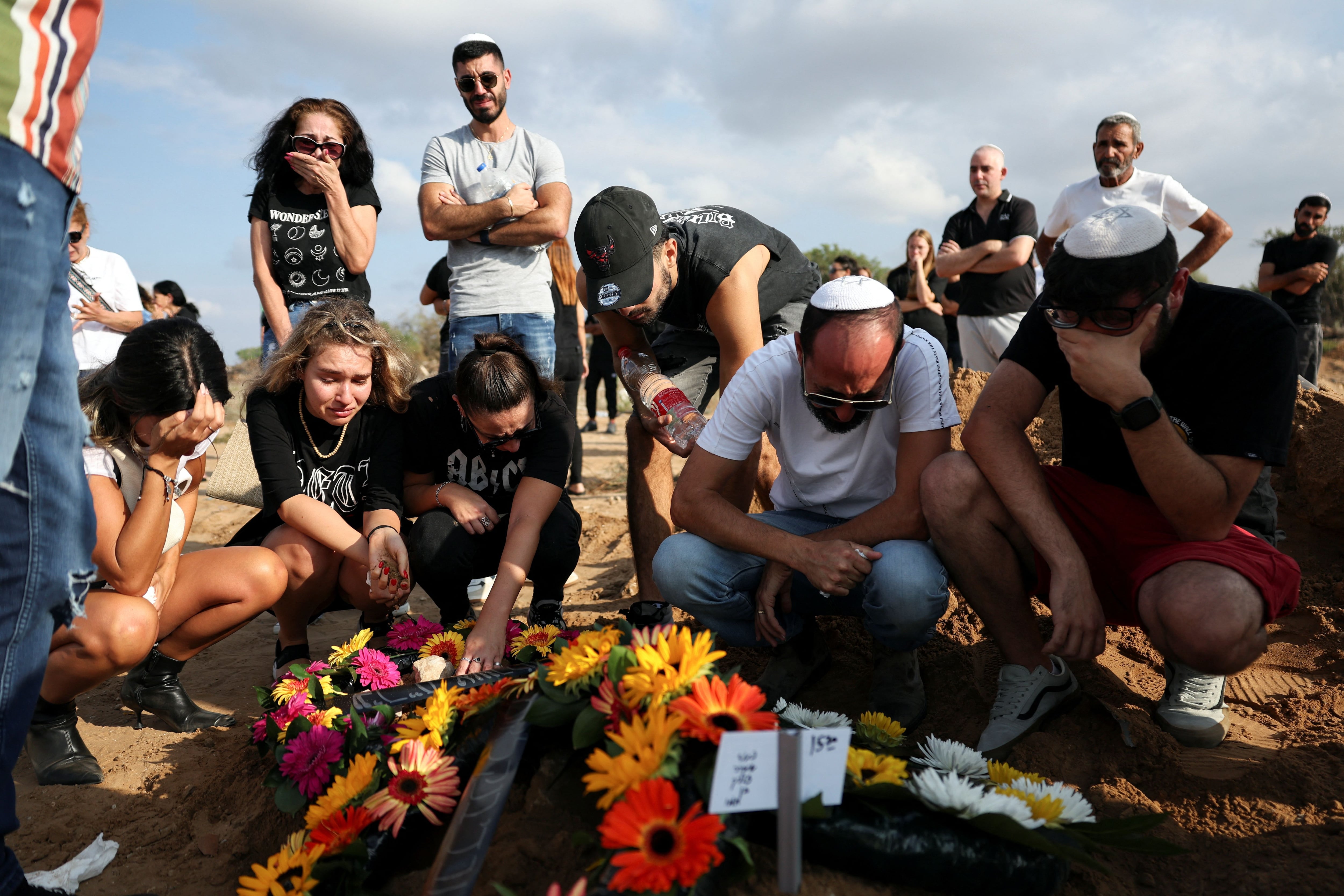 La gente llora junto a la tumba de Eden Guez, quien fue asesinada mientras asistía a un festival atacado por hombres armados de Hamas desde Gaza que dejó al menos 260 muertos, en su funeral en Ashkelon, en el sur de Israel, el 10 de octubre de 2023 (REUTERS/Violeta Santos Moura)