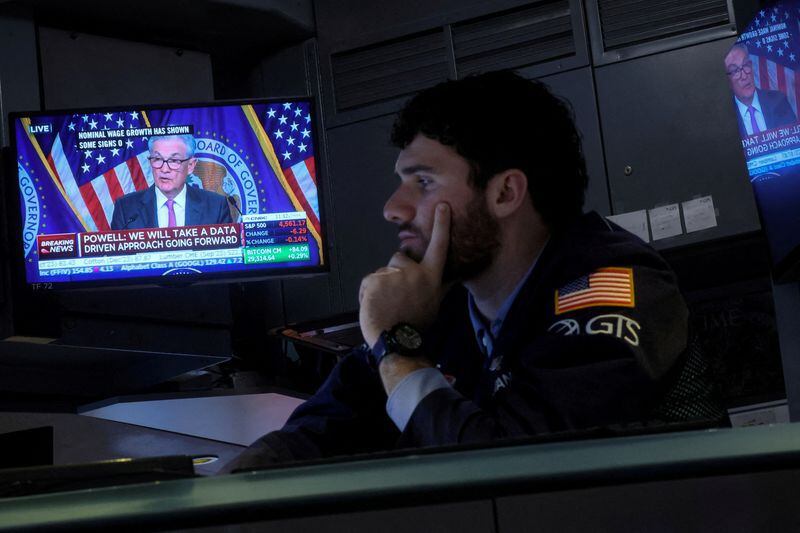 Un operador trabaja mientras una pantalla muestra una conferencia de prensa del presidente de la Junta de la Reserva Federal, Jerome Powell (REUTERS/Brendan McDermid)