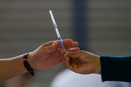 A person passes a syringe to another person during a mass vaccination against the coronavirus disease (COVID-19) in Mexico City, Mexico February 24, 2021. REUTERS/Carlos Jasso