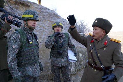 Soldado norcoreano (R) hablando con soldados surcoreanos durante una inspección del puesto fronterizo norcoreano desmantelado en la Zona Desmilitarizada (DMZ) que divide las dos Coreas en Cheorwon.  (AFP)