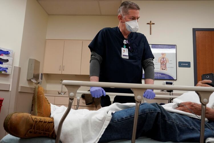 El Capellán Bill Simpson habla con un paciente en la sala de emergencias del Hospital SSM Health St. Anthony en medio de la propagación de coronavirus en Shawnee, Oklahoma, EE.UU. 23 de abril de 2020. (REUTERS/Nick Oxford)